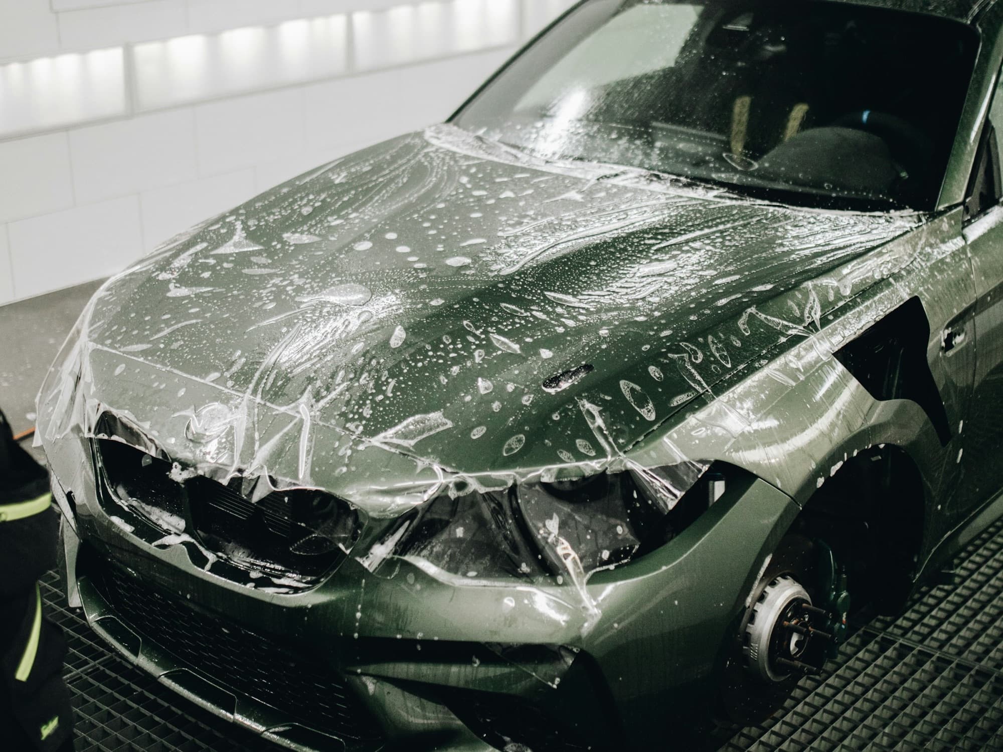 Clear paint protection film being applied to a car's hood